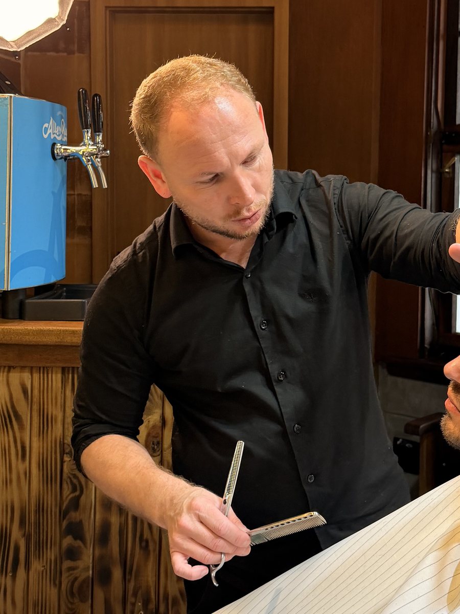 Claudio cortando o cabelo de um cliente na Old Town